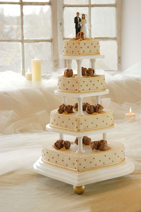 Flot hjertedame bryllupskage med brudepar på toppen